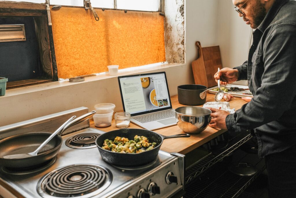 a man standing in front of a stove preparing food